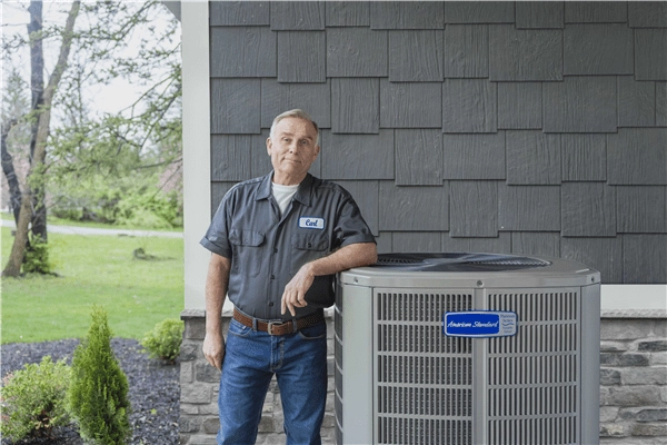 Technician inspecting an outdoor air conditioner condenser unit