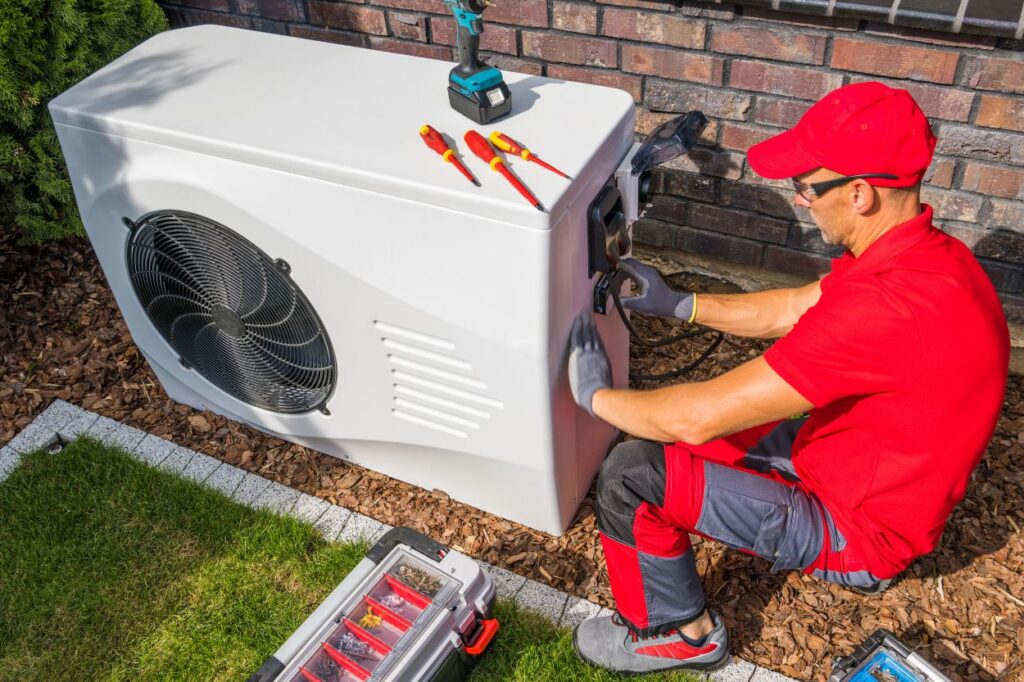 Service technician repairing an outdoor air conditioning unit