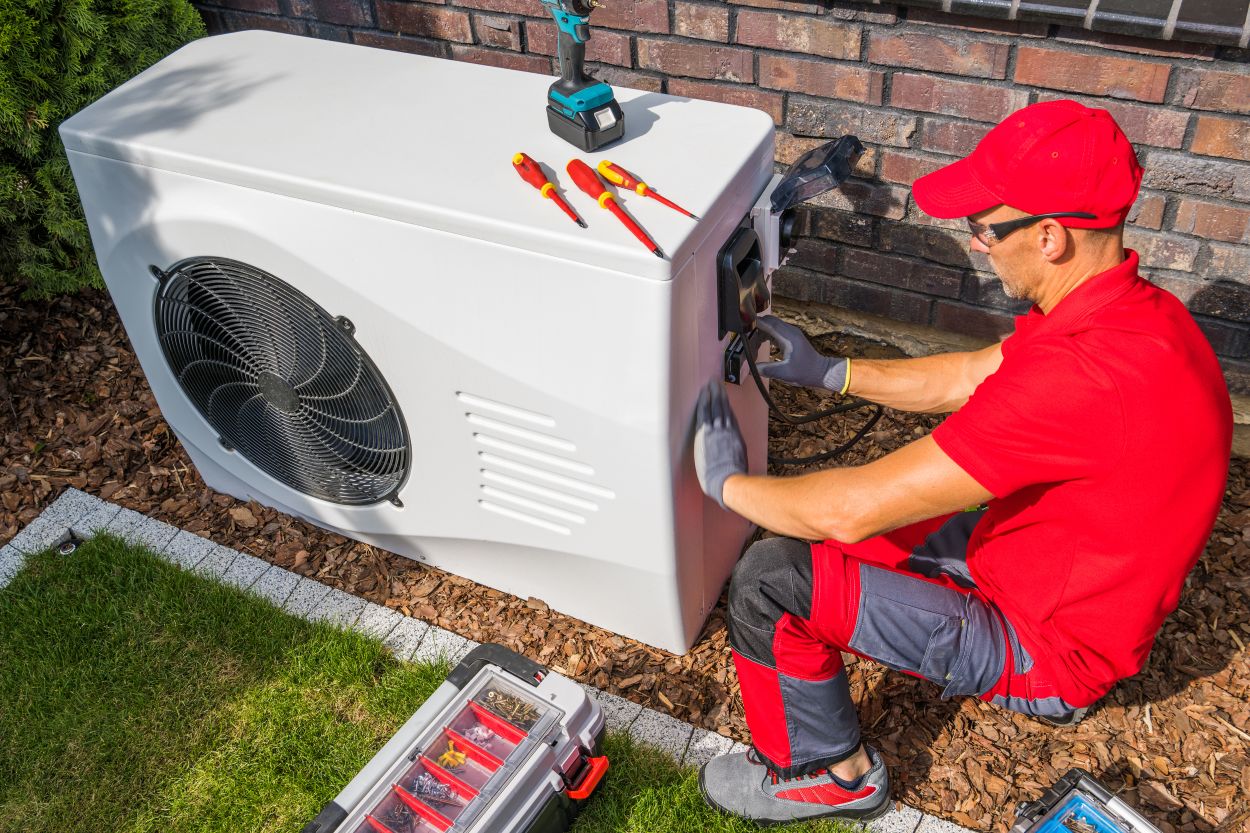 Service technician repairing an outdoor air conditioning unit