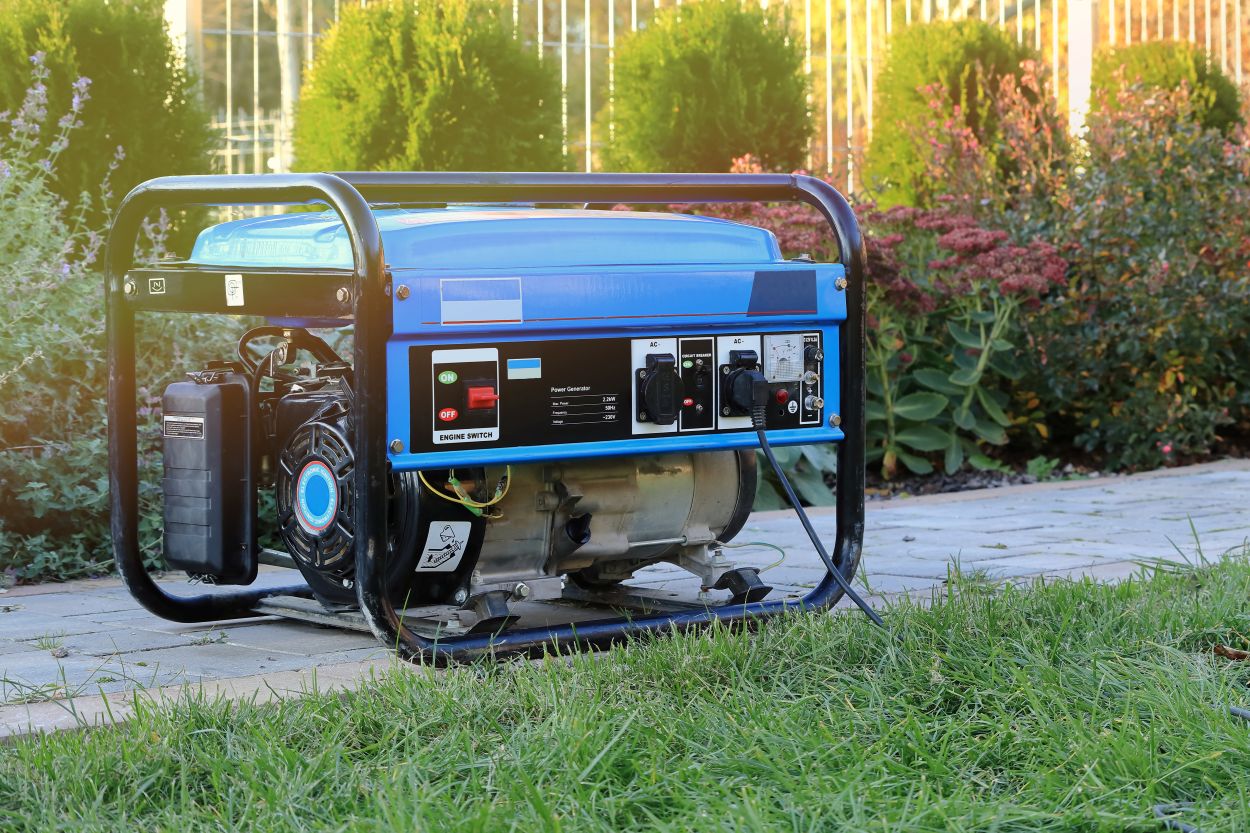 Power generator standing in the garden on the pavement.